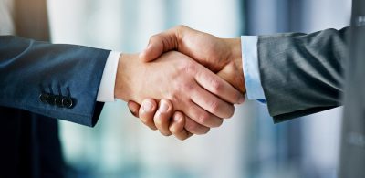 Closeup shot of two businessmen shaking hands in an office
